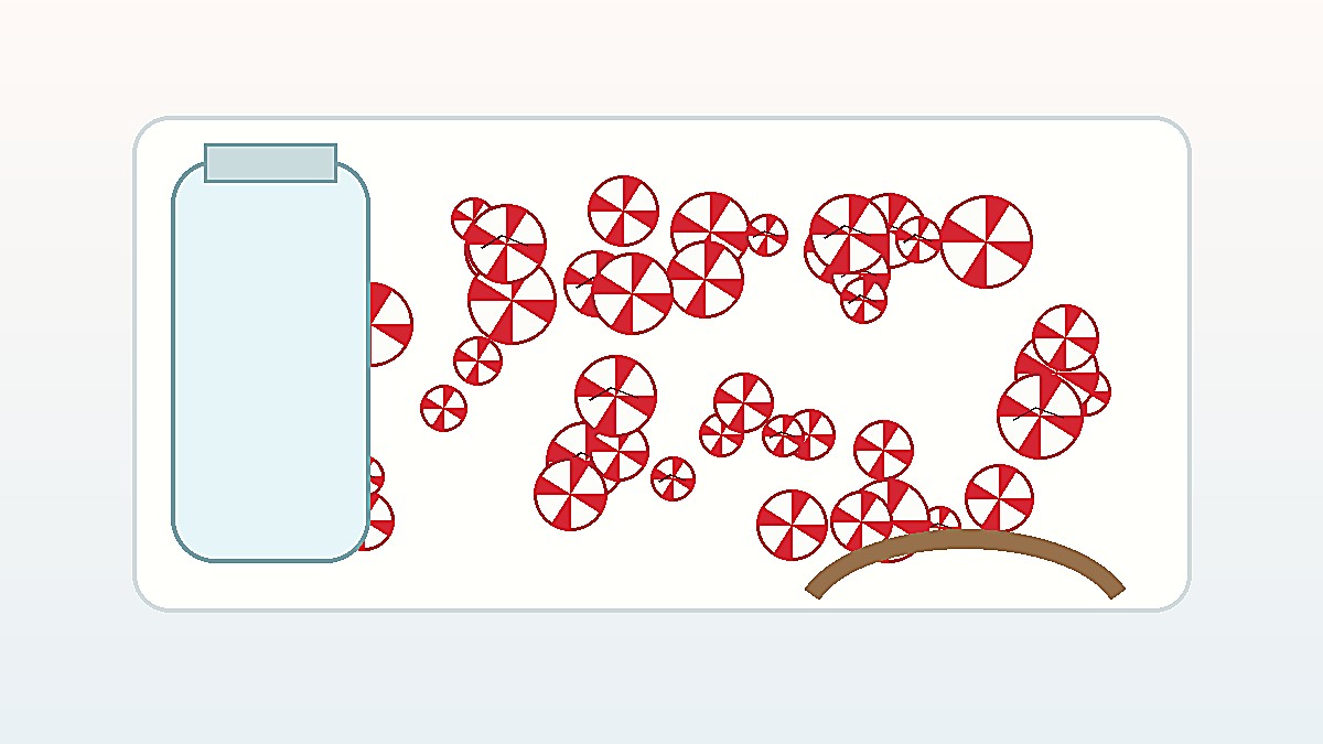 Red and white crushed peppermint candy pieces beside a clear storage jar